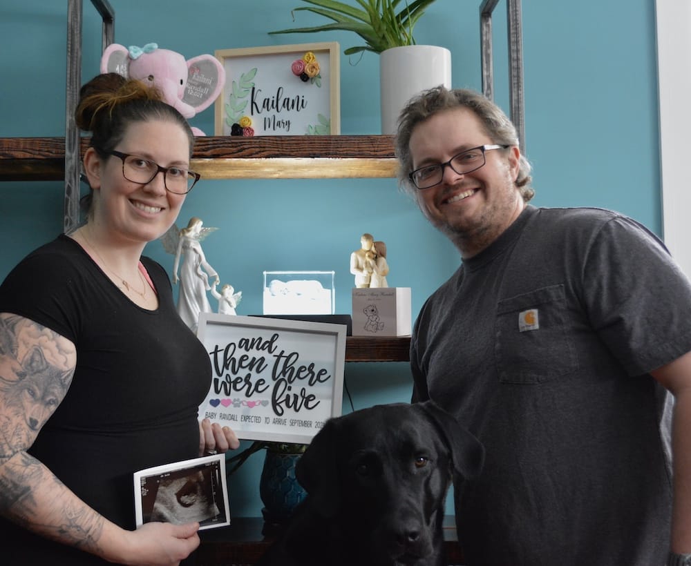 LaCara, her husband, and dog announcing pregnancy